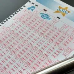 Kupon gry Lotto z zaznaczonymi polami i długopisem.