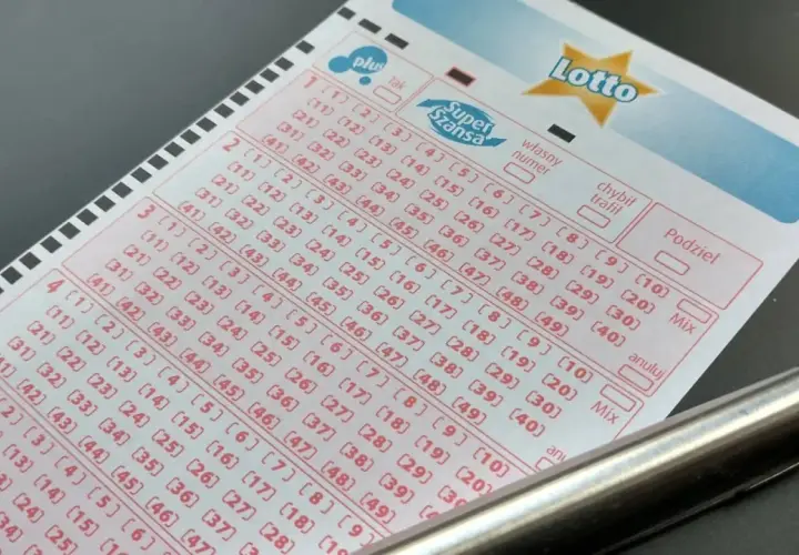 Kupon gry Lotto z zaznaczonymi polami i długopisem.