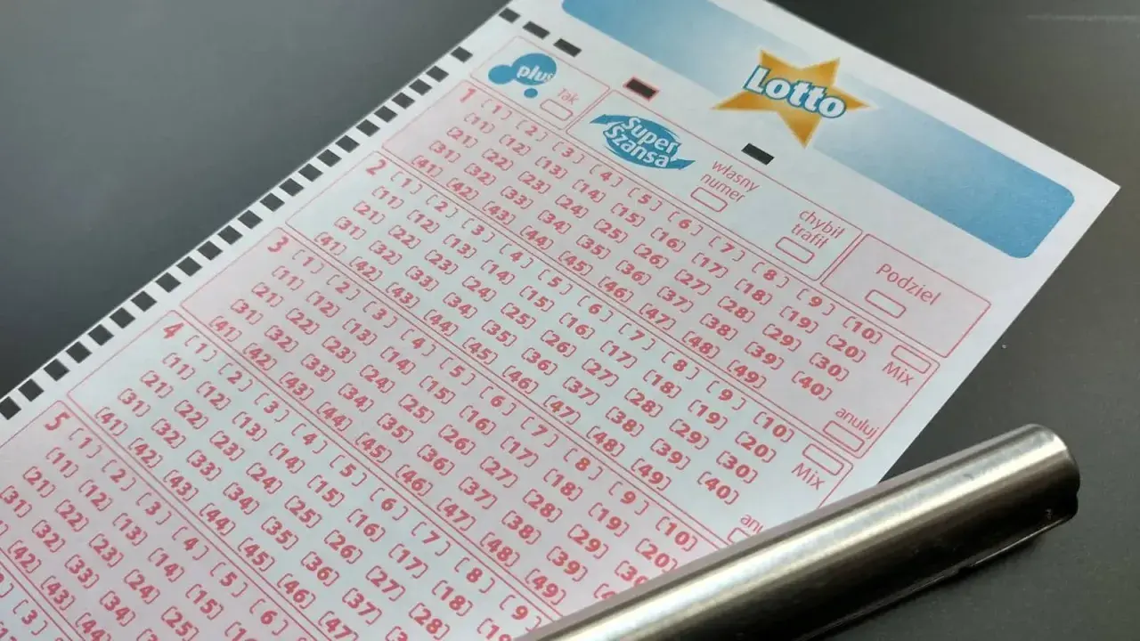 Kupon gry Lotto z zaznaczonymi polami i długopisem.
