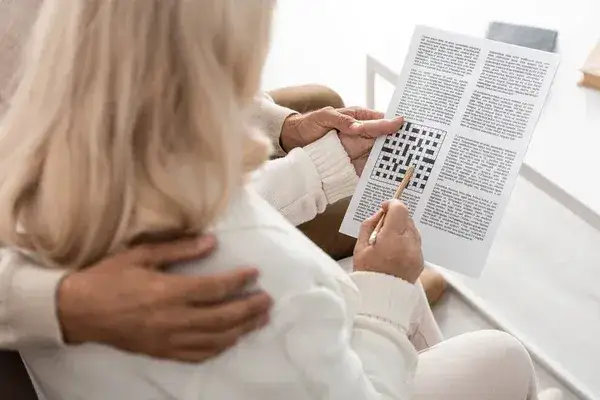 kobieta rozwiązująca krzyż&oacute;wkę, oł&oacute;wek, gazeta